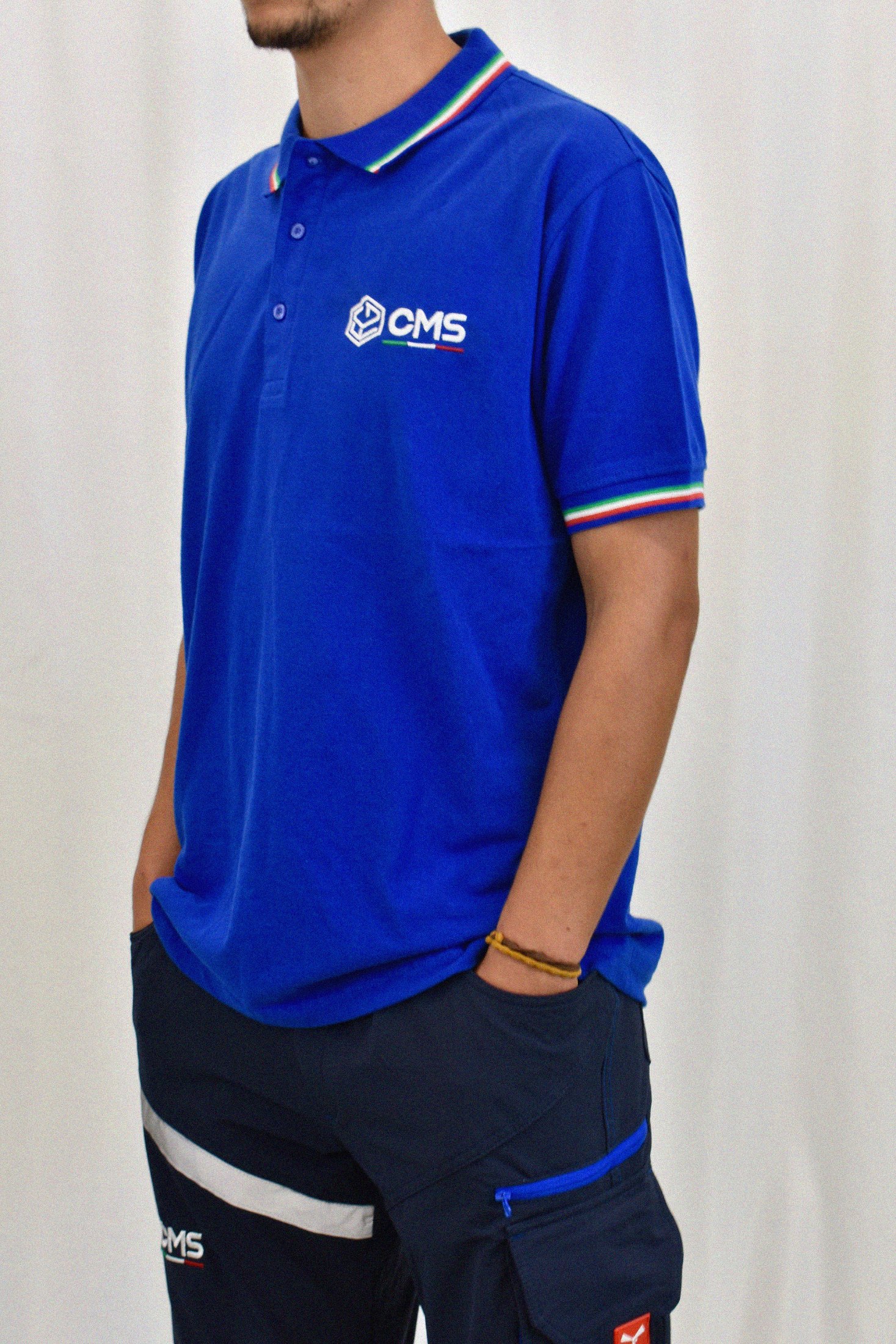 La polo della divisa con il logo CMS ricamato e il bordo tricolore