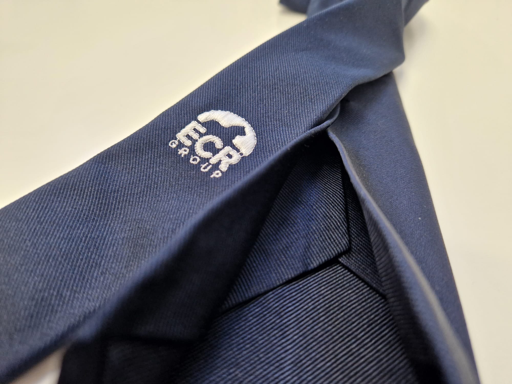 Dettaglio del ricamo ECR Group sulla seta twill