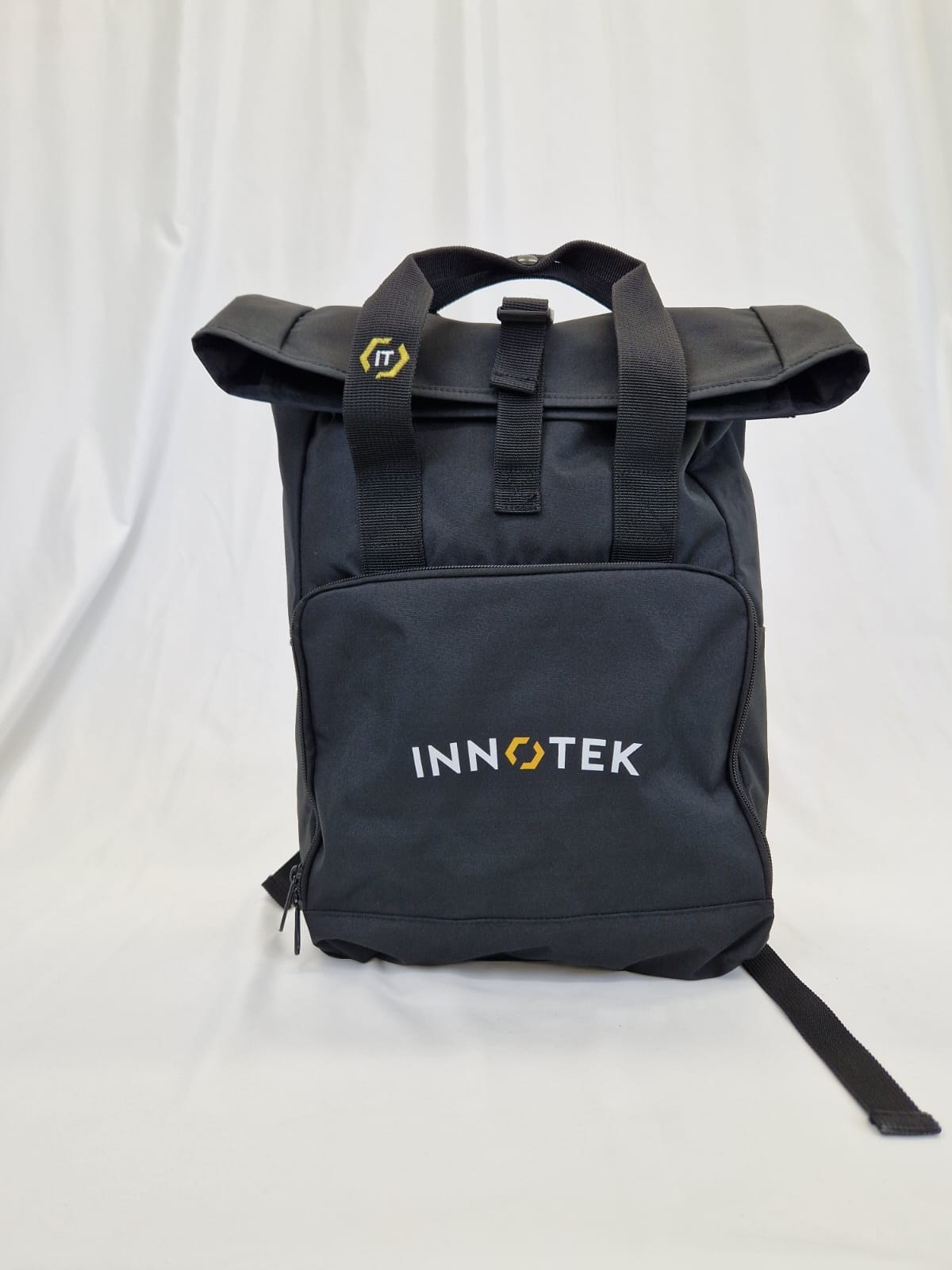 Lo zaino Innotek nero con chiusura roll-top, maniglie e tasca frontale con il logo