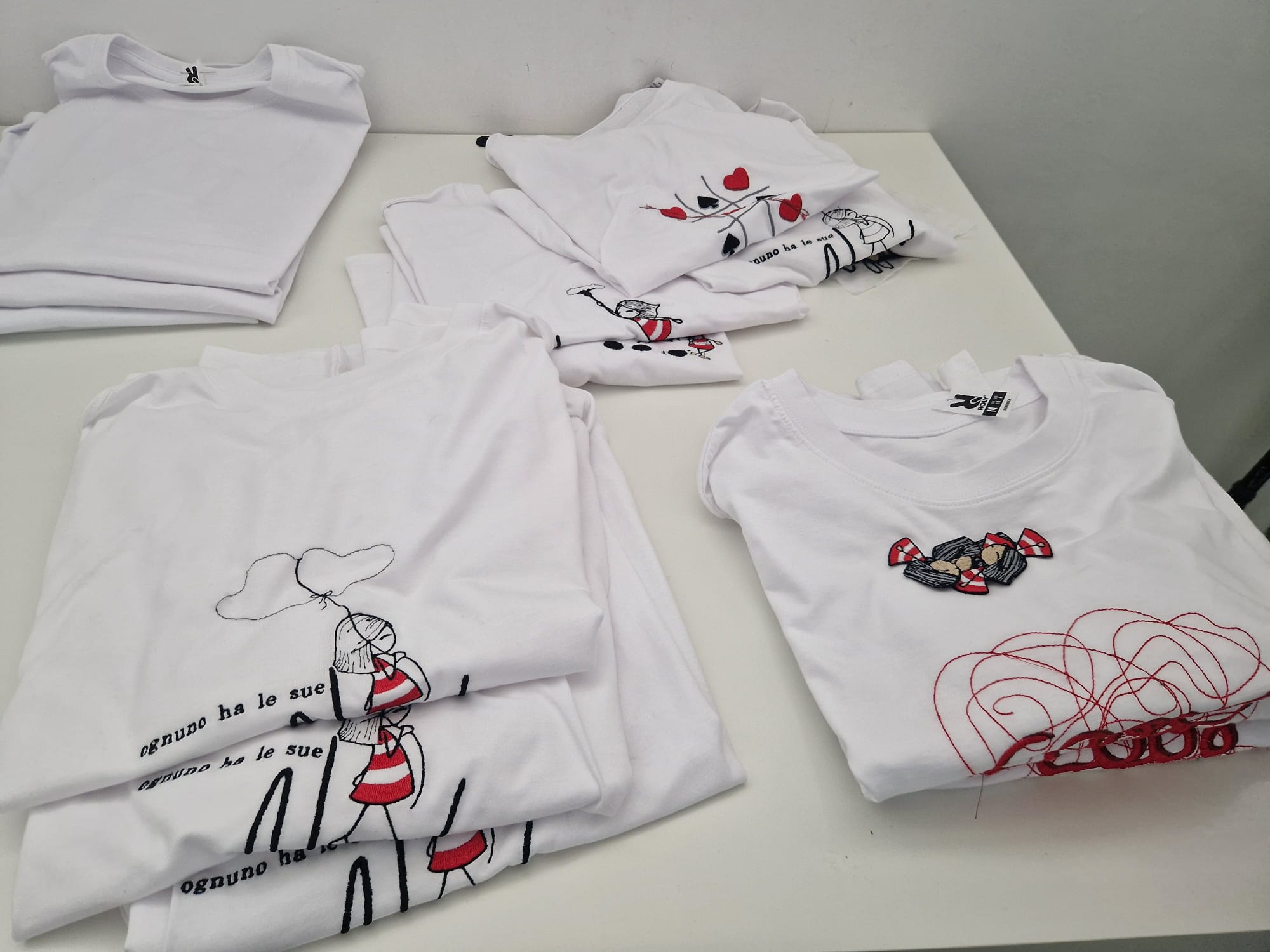 T-shirt bianche piegate con la Tipa e i suoi pensieri ricamati