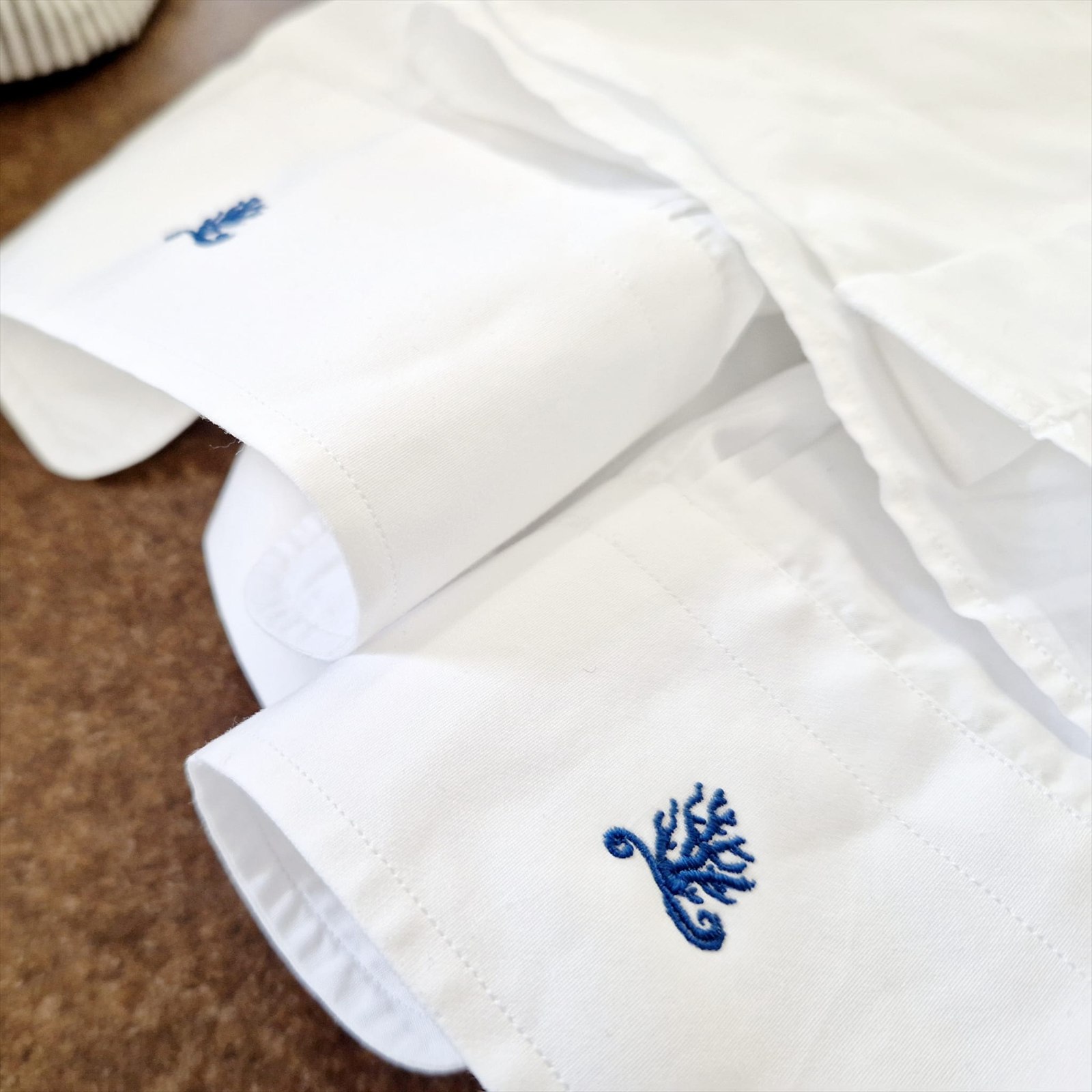 Camicia bianca con il corallo ricamato in blu su polsino e colletto