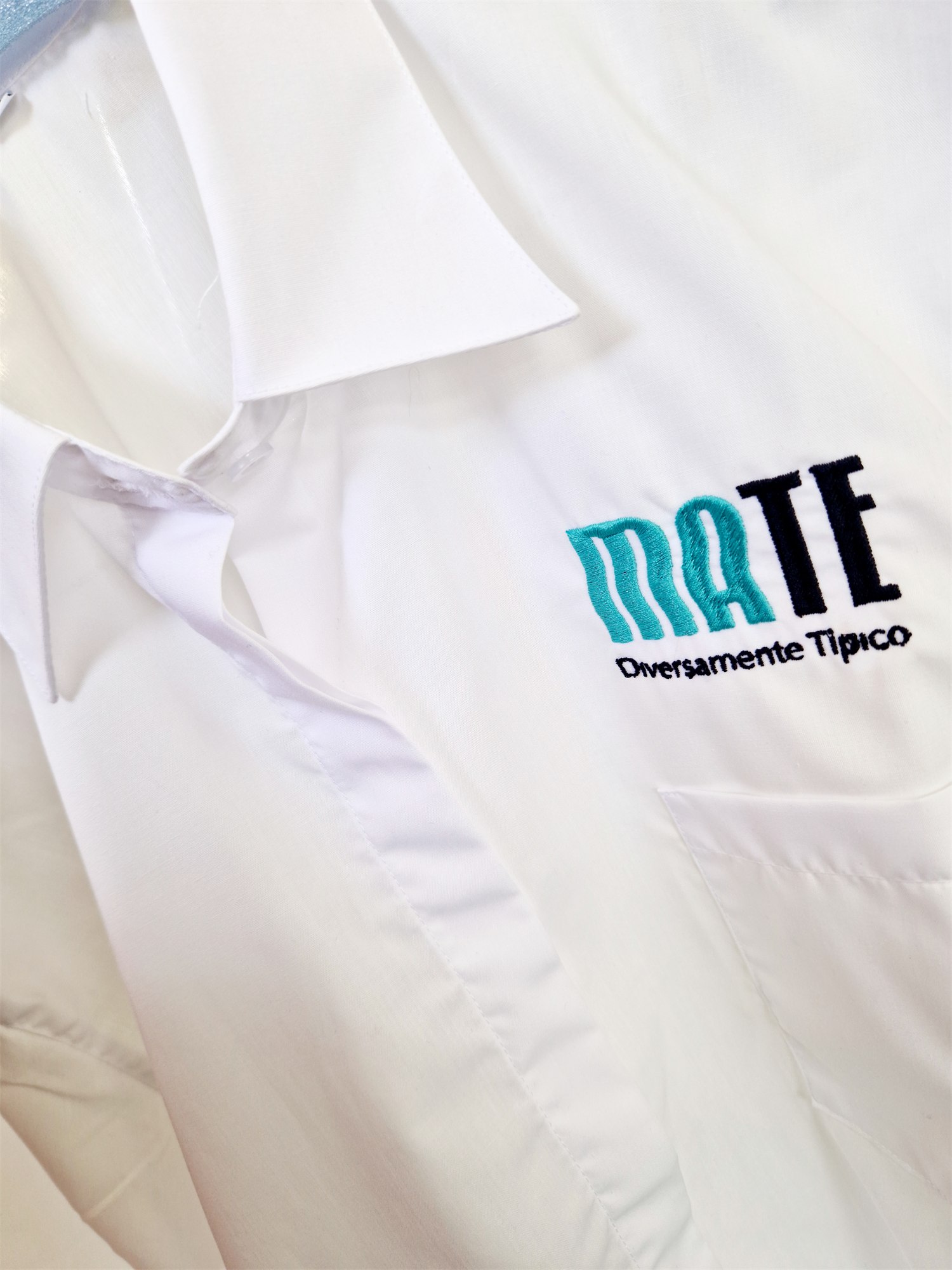 The Mate Diversamente Tipico logo embroidered on the white shirt